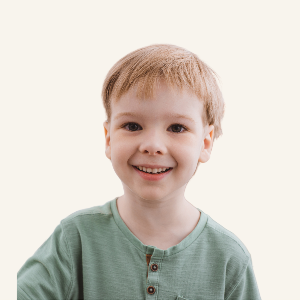 Young child with short light brown hair, wearing a light green shirt, smiles at the camera against a plain light background.